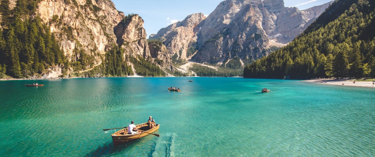 three brown wooden boat on blue lake water taken at daytime