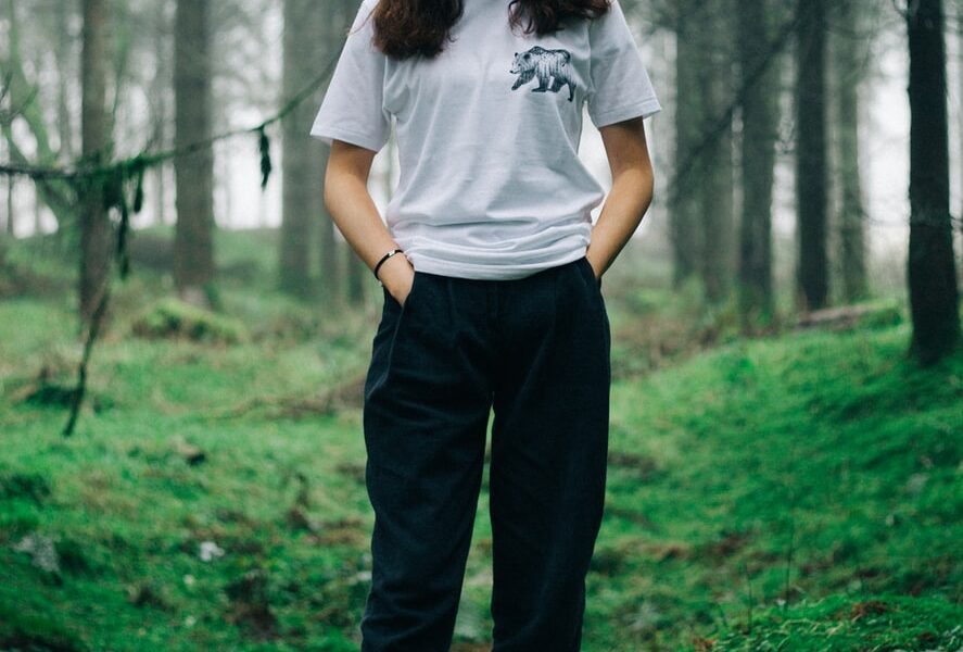 woman standing in middle of forest